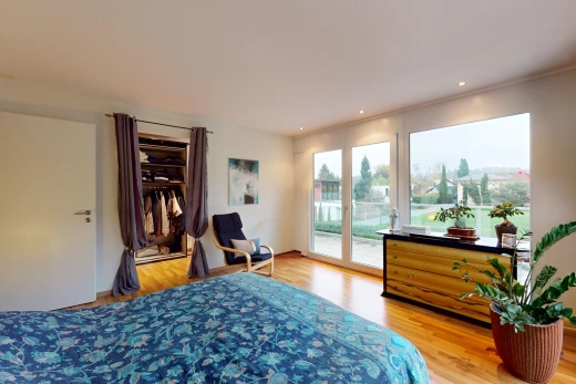 chambre avec plancher de bois, lumière naturelle, et accès à l'extérieur