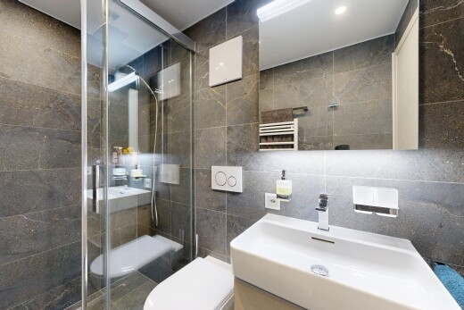 salle de bains avec chauffe-serviettes, miroir, mur en carrelage, tile wall, et salle de bain complète