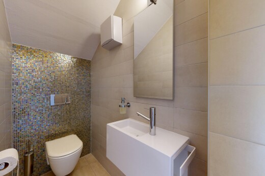 salle de bains avec tile wall, mur en carrelage, vaulted ceiling, plafond voûté, et tile floor