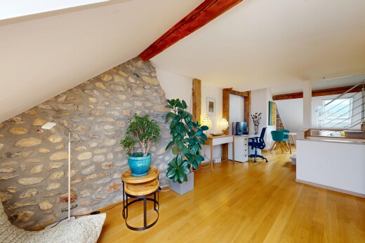 salon avec mur en pierre, stone wall, espace bureau, inside property, et sol en finition bois