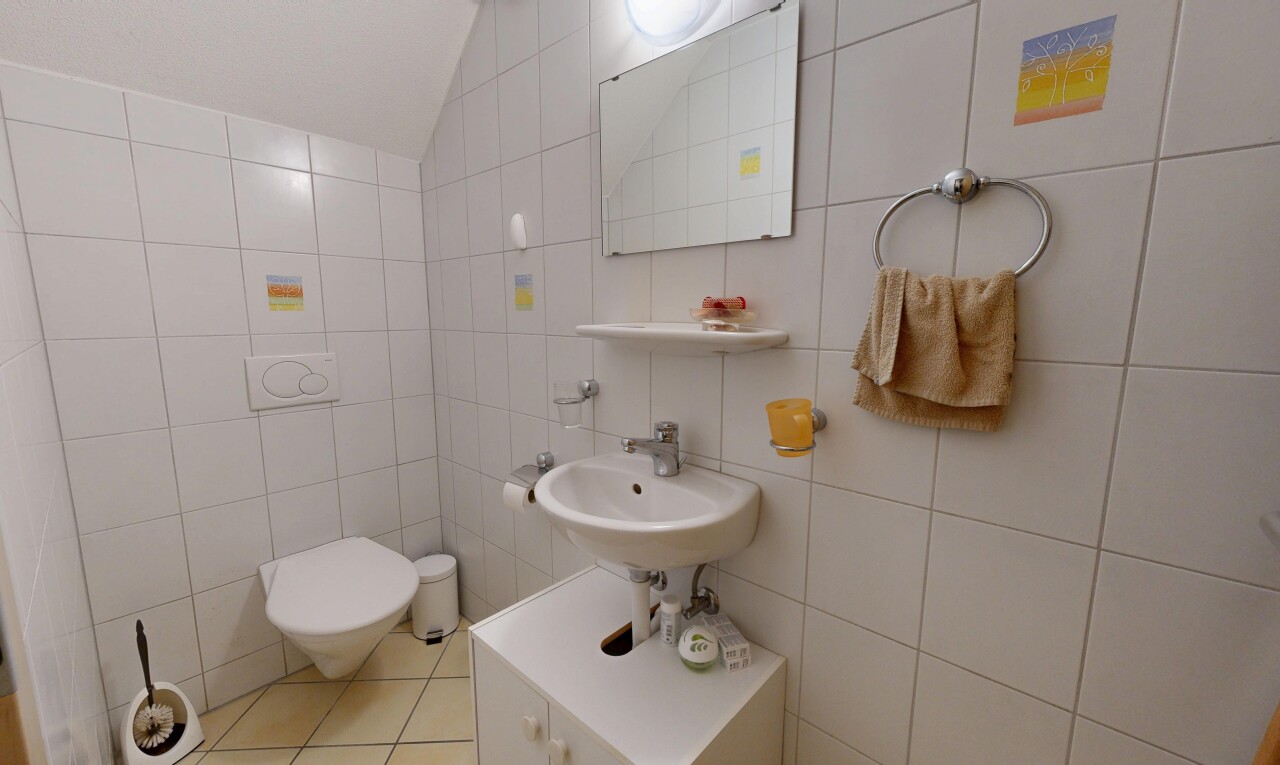 salle de bains avec miroir, mur en carrelage, tile wall, plafond voûté, et vaulted ceiling