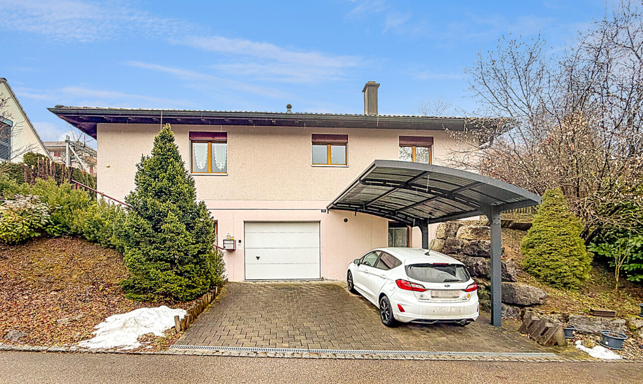 façade avec garage intégré, property visible, bardage en stuc, day time, et abri de voiture