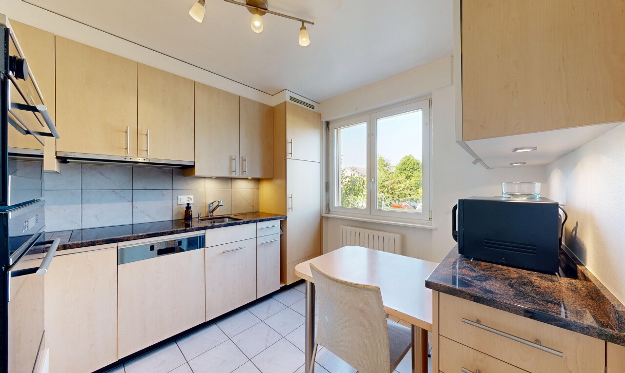 cuisine avec light brown cabinets, armoires marron clair, dark countertops, dosseret, et backsplash