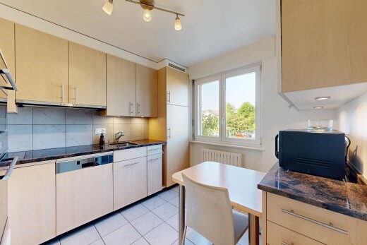 cuisine avec light brown cabinets, armoires marron clair, dark countertops, dosseret, et backsplash