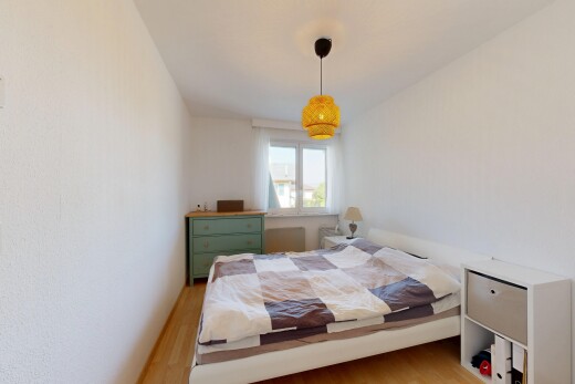 chambre avec éclairage suspendu, wood finish floor, sol en finition bois, lumière naturelle, et inside property