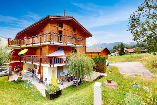 außenansicht mit terrasse, holzverkleidung, blick auf die berge, mountain view, und rasen