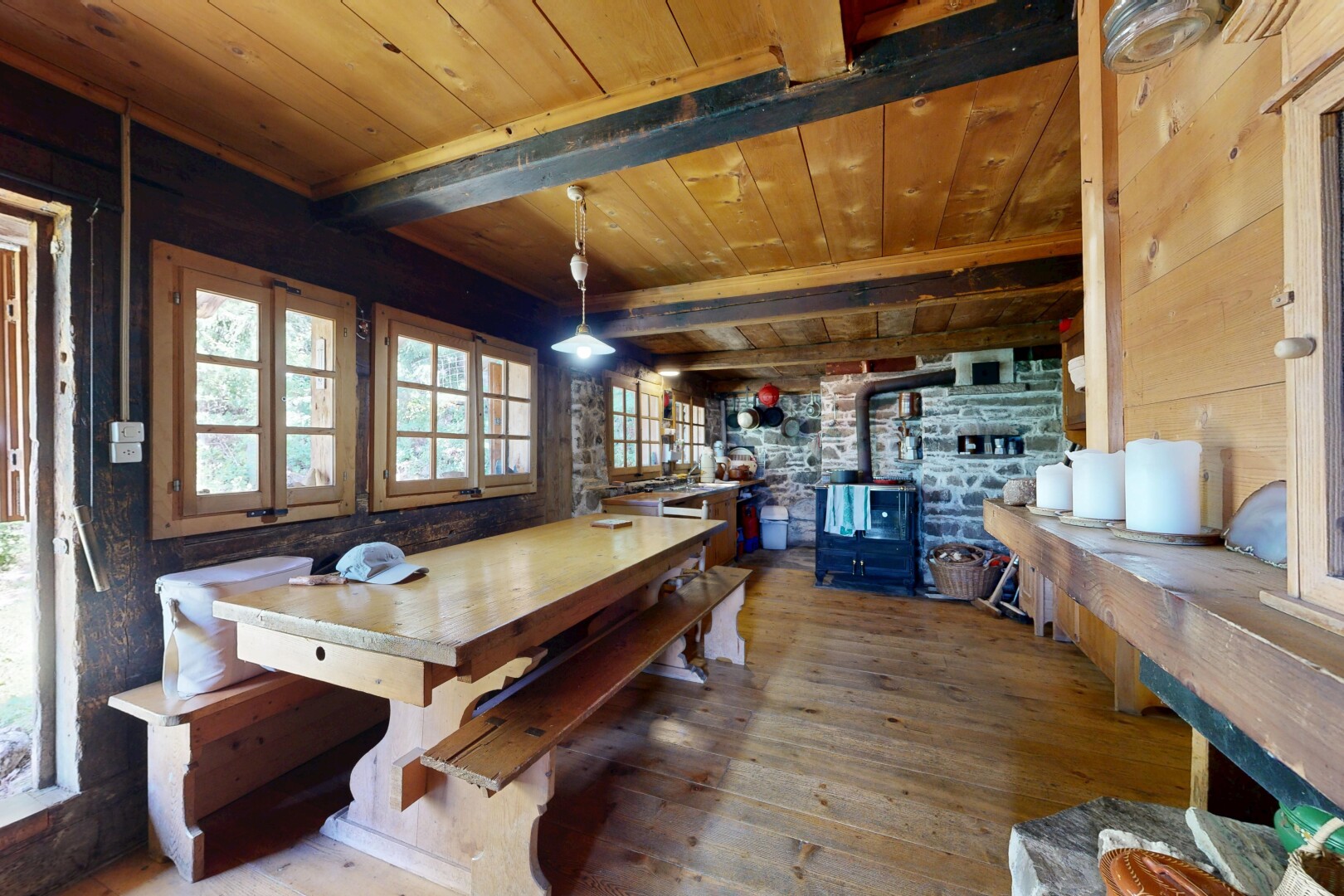 salle à manger avec poêle à bois, plafond en bois, wood ceiling, inside property, et lumière naturelle