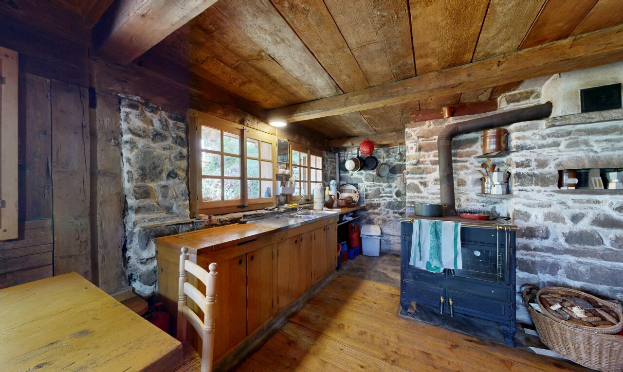 cuisine avec poêle à bois, sol en finition bois, wood finish floor, plafond en bois, et wood ceiling