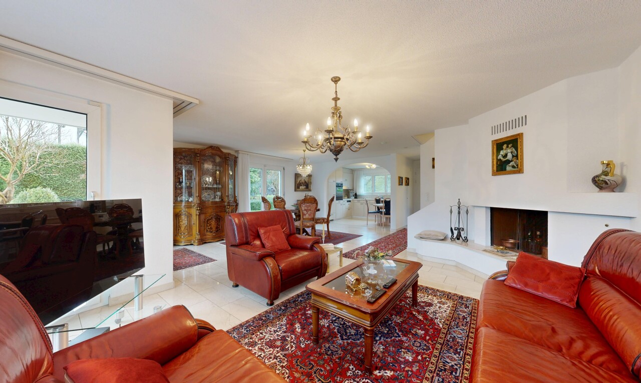 wohnzimmer mit fernseher, gewölbte gehwege, bemerkenswerter kronleuchter, natürliches licht, und natural light