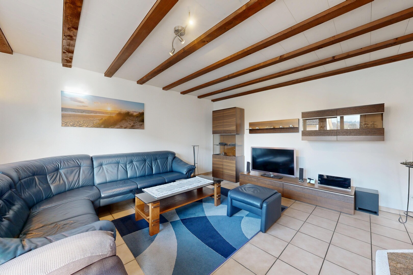 living room featuring tile patterned floors and beamed ceiling