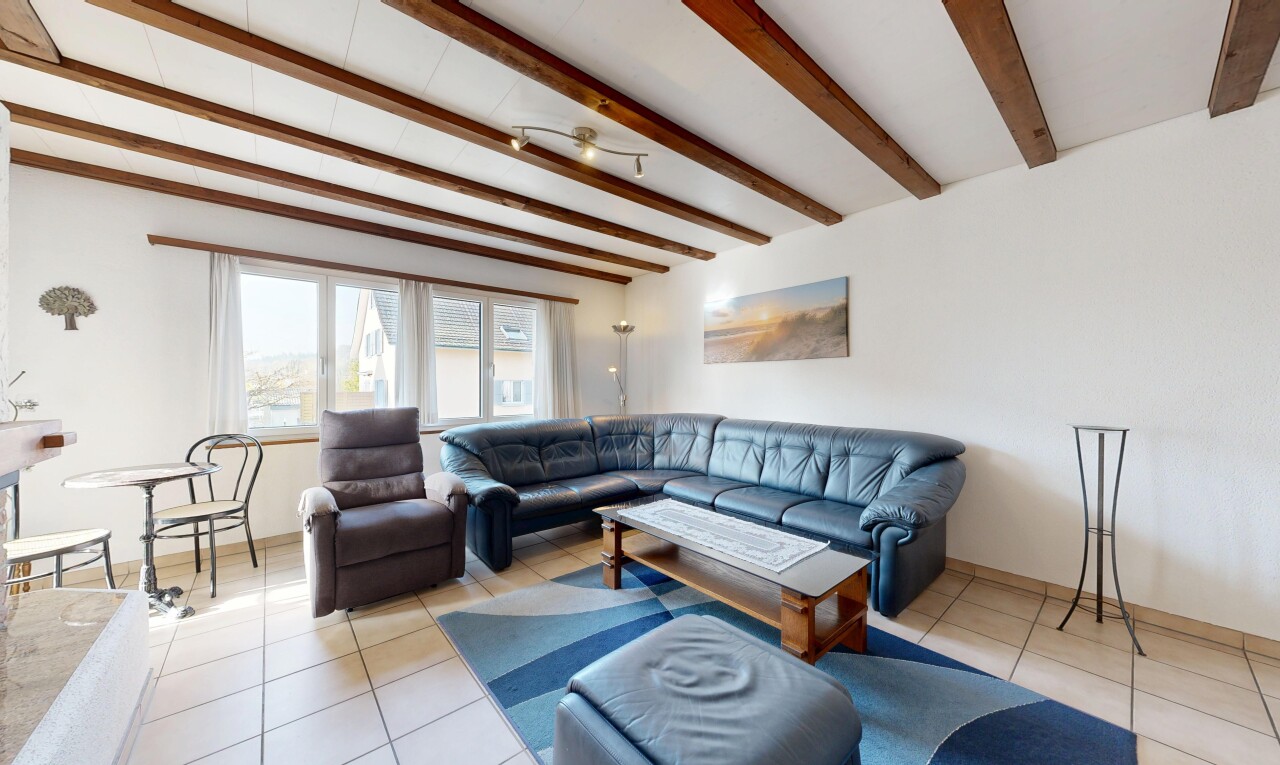 living room with light tile patterned floors and beam ceiling