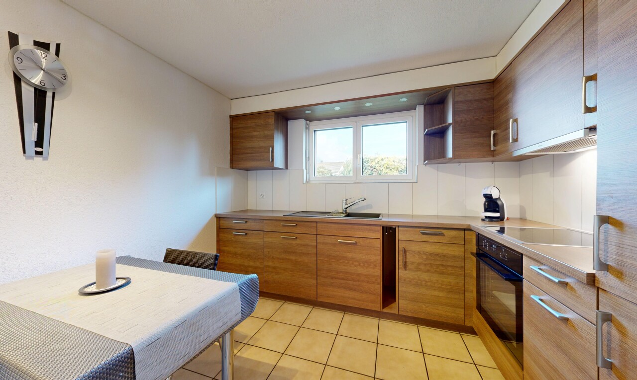 kitchen with black appliances, brown cabinetry, light countertops, light tile patterned flooring, and ventilation hood