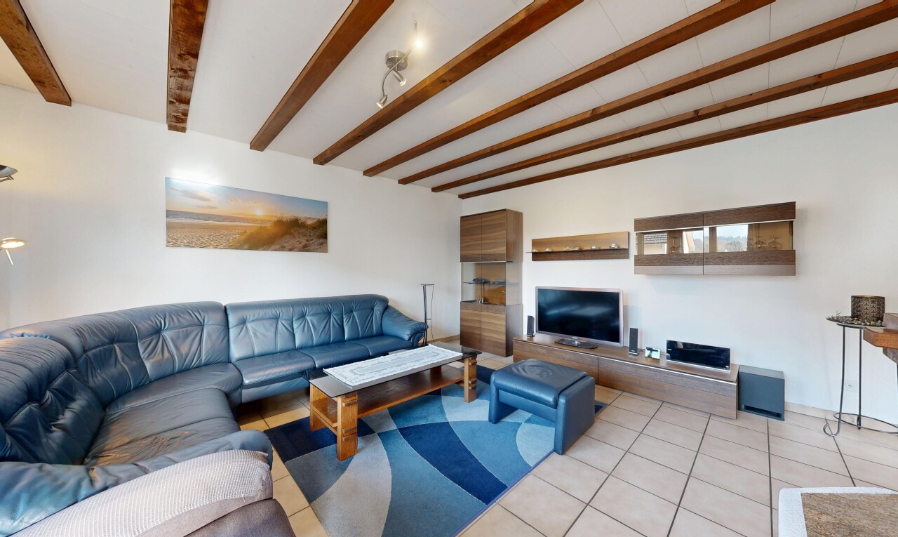 living room featuring tile patterned floors and beamed ceiling