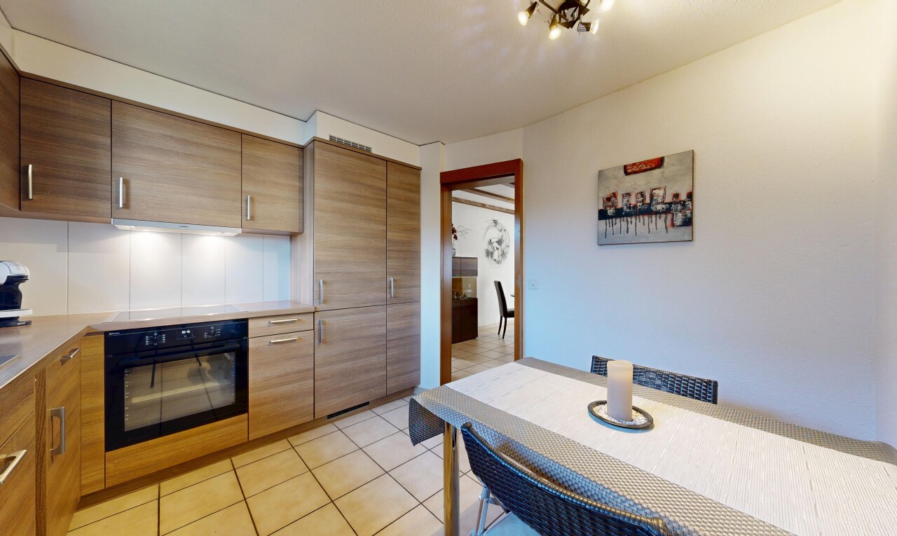 kitchen featuring black oven, light tile patterned flooring, light countertops, and modern cabinets