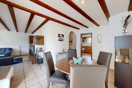 dining space with arched walkways, beam ceiling, and light tile patterned floors