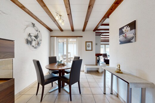 dining area with beamed ceiling and light tile patterned floors