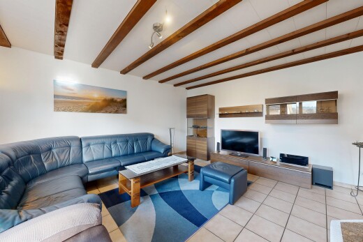 living room featuring tile patterned floors and beamed ceiling