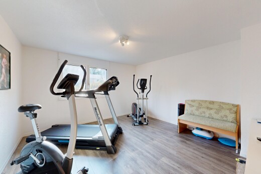 gym avec sol en finition bois, wood finish floor, cloison sèche, drywall, et lumière naturelle