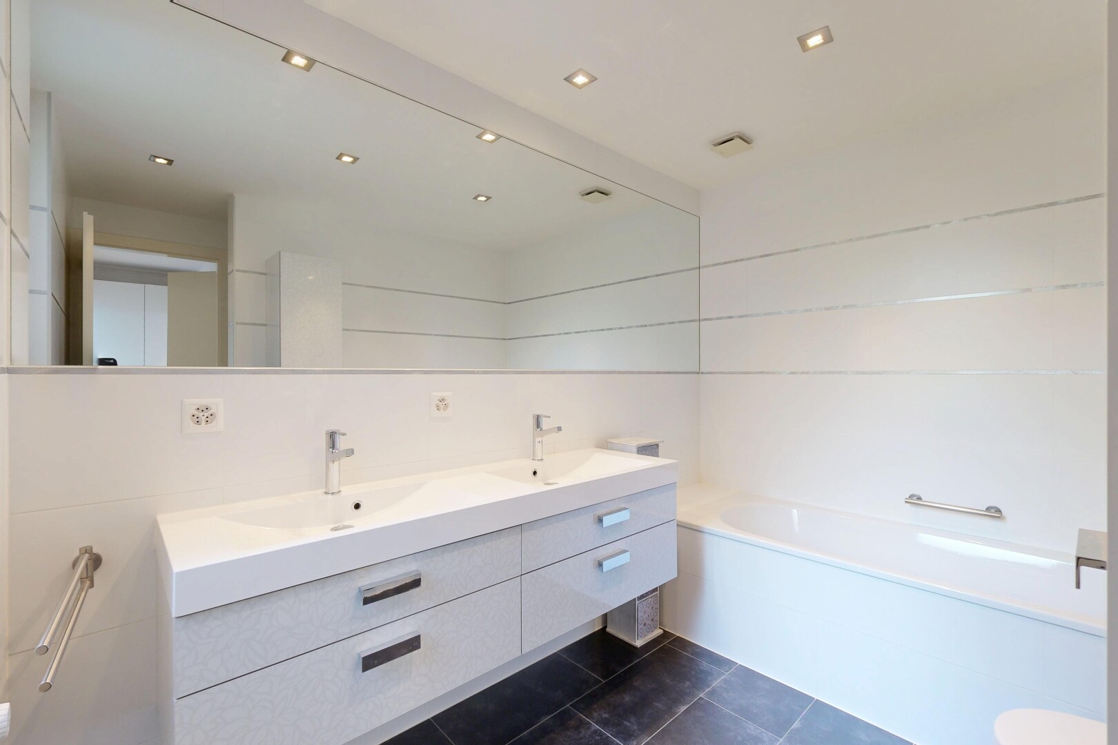 bathroom featuring double vanity, a garden tub, dark tile patterned flooring, recessed lighting, and tile walls