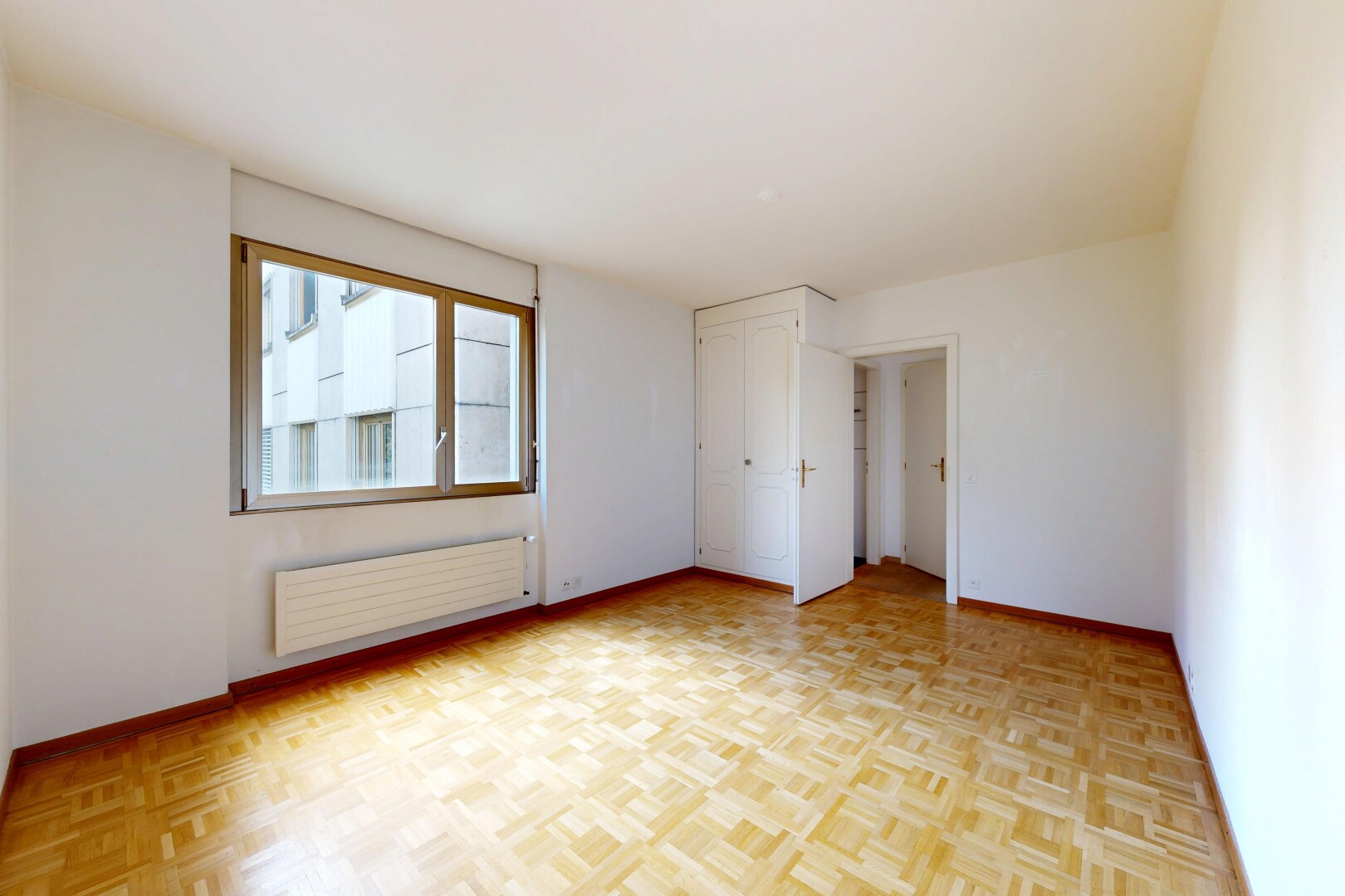 empty room featuring radiator and parquet floors