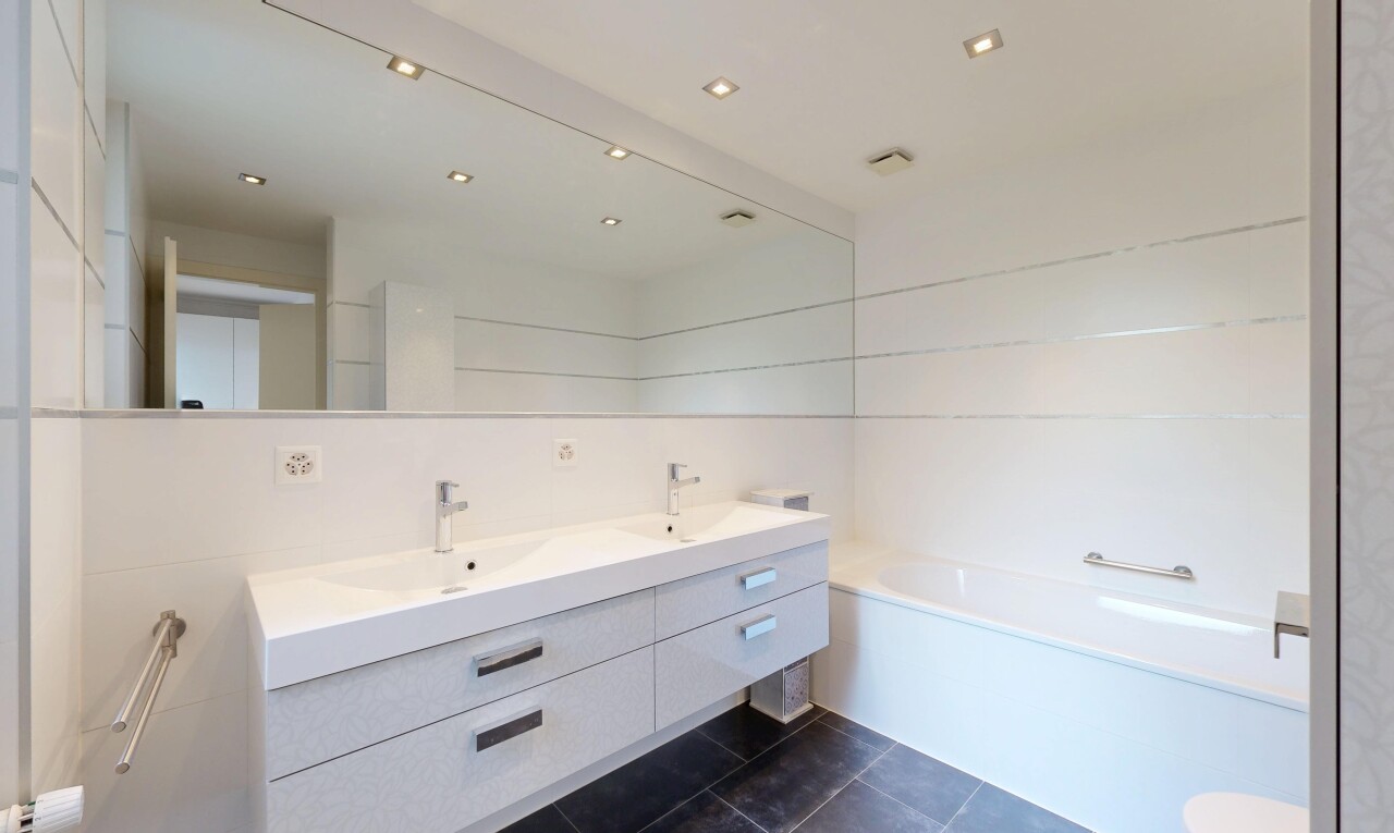 bathroom featuring double vanity, a garden tub, dark tile patterned flooring, recessed lighting, and tile walls