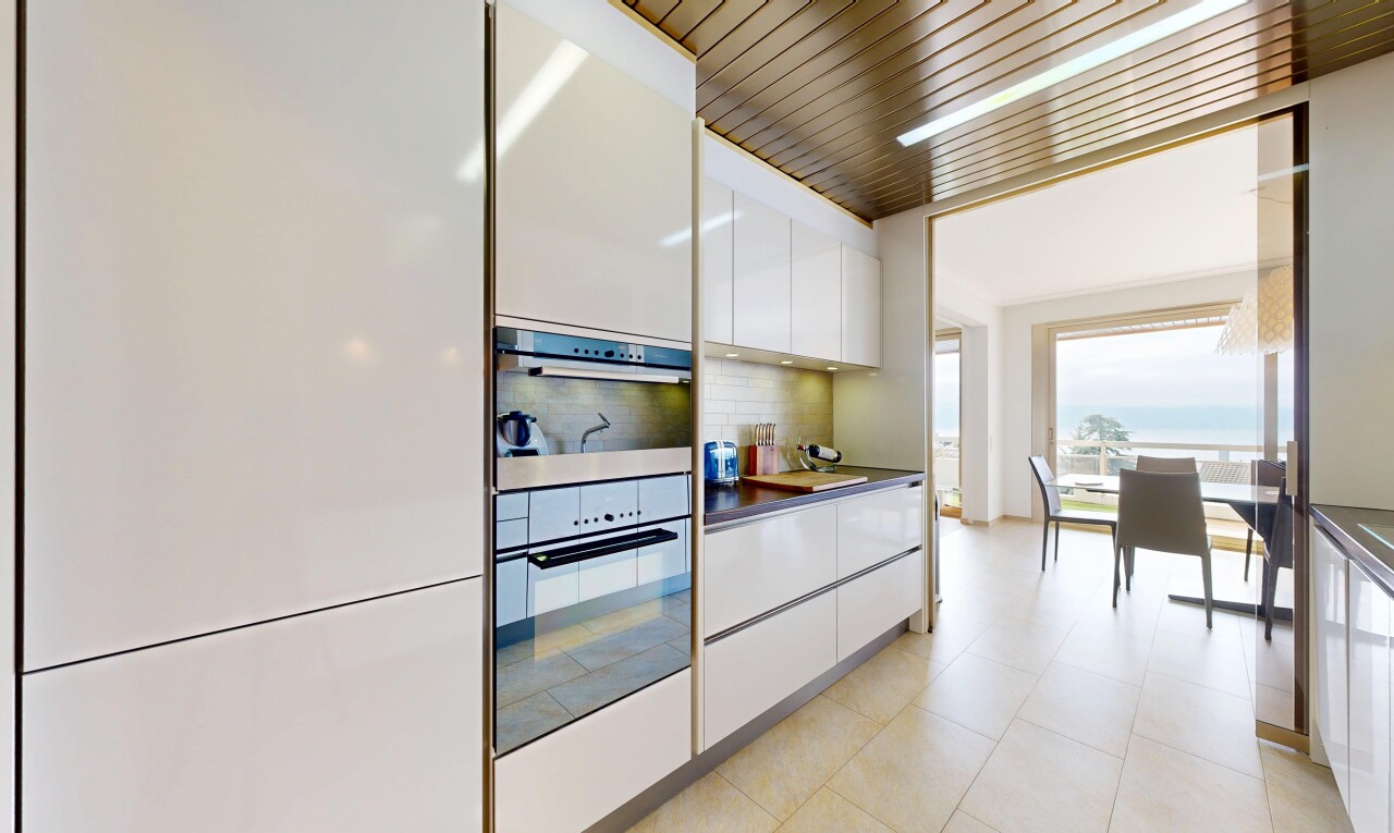 kitchen featuring white cabinets, dark countertops, stainless steel double oven, modern cabinets, and tasteful backsplash