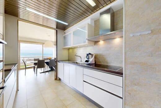 cuisine avec armoires blanches, white cabinets, hotte, plans de travail, et dark countertops