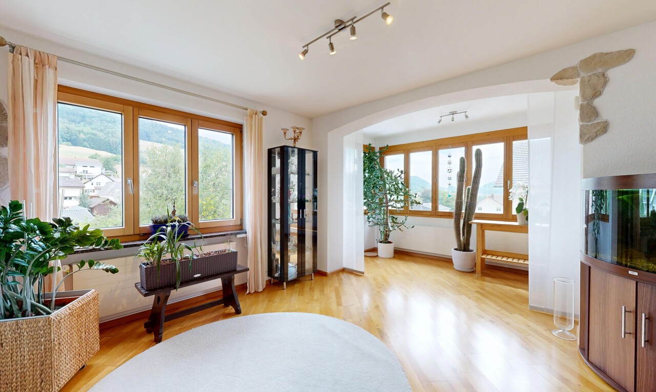 wohnzimmer mit deckenbeleuchtung, holzfußboden, wood finish floor, gewölbte gehwege, und inside property