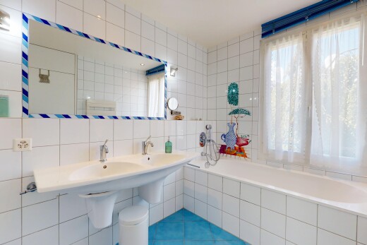 bathroom with tile walls, tiled bath, and tasteful backsplash
