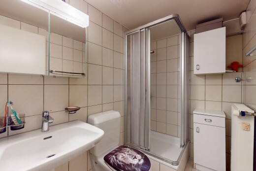 salle de bains avec tile wall, mur en carrelage, évier, douche, et inside property