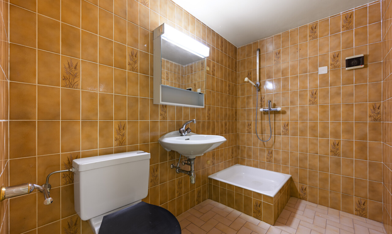 full bath with tile walls and a tile shower