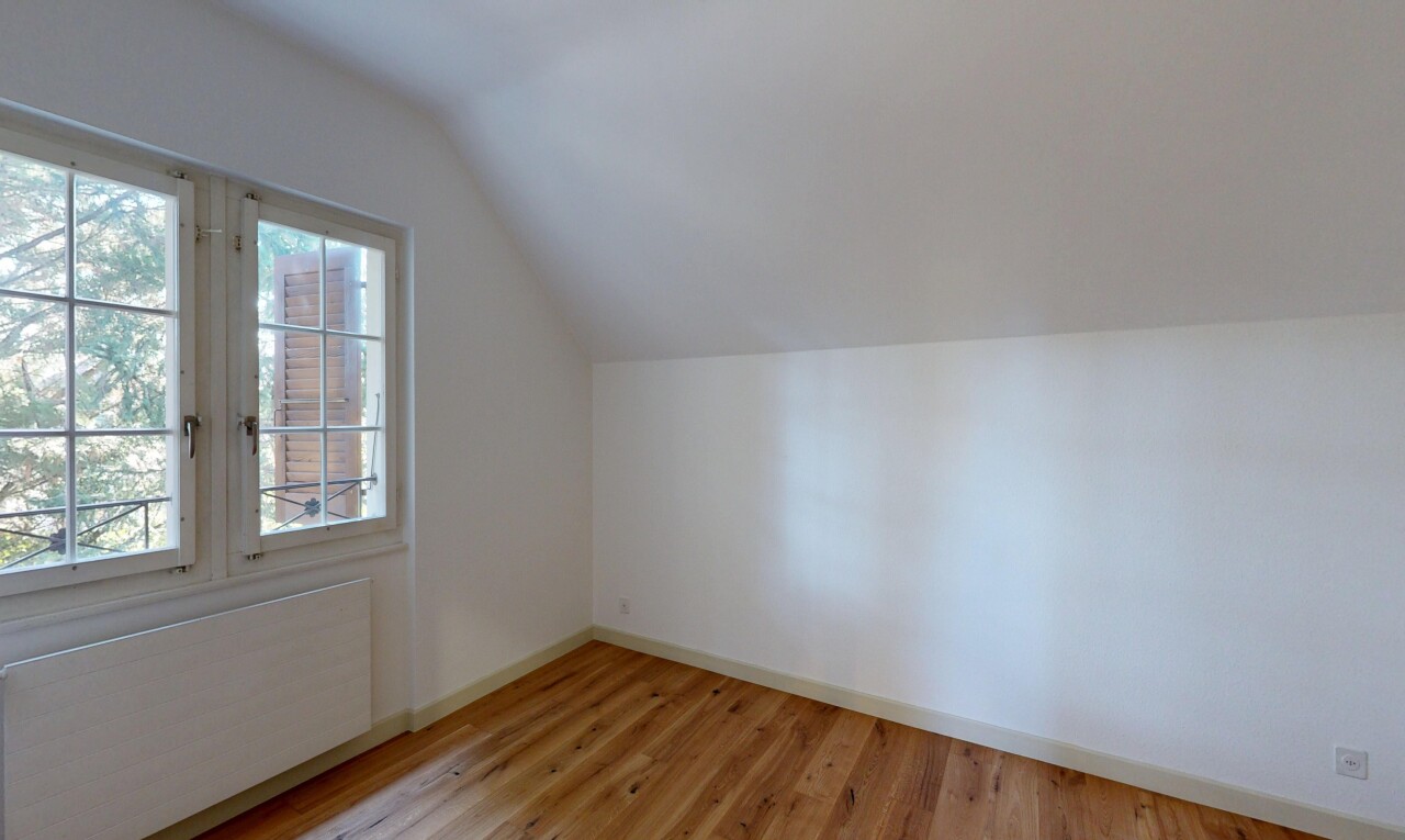 empty room featuring radiator heating unit, vaulted ceiling, and light wood-type flooring