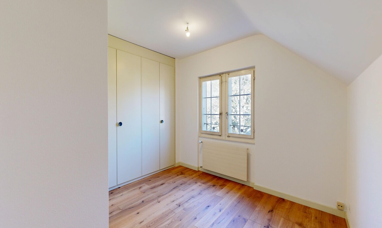 empty room with radiator heating unit, light wood-style floors, and lofted ceiling
