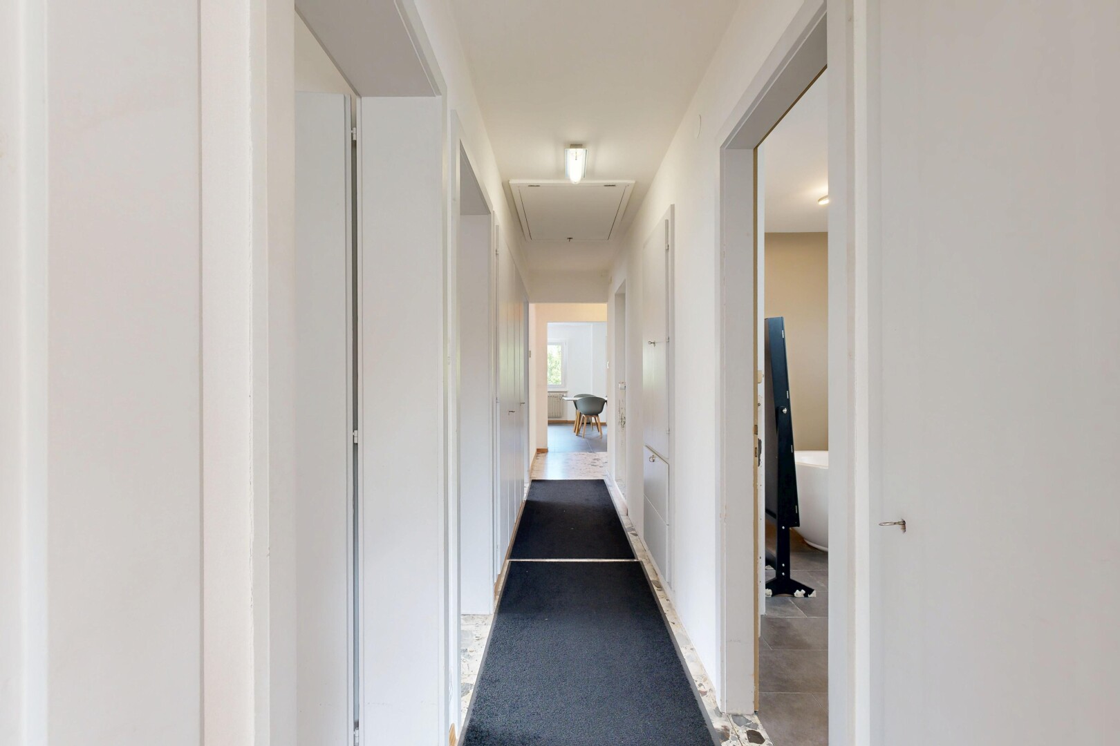 couloir avec inside property, light floor, cloison sèche, drywall, et escaliers escamotables