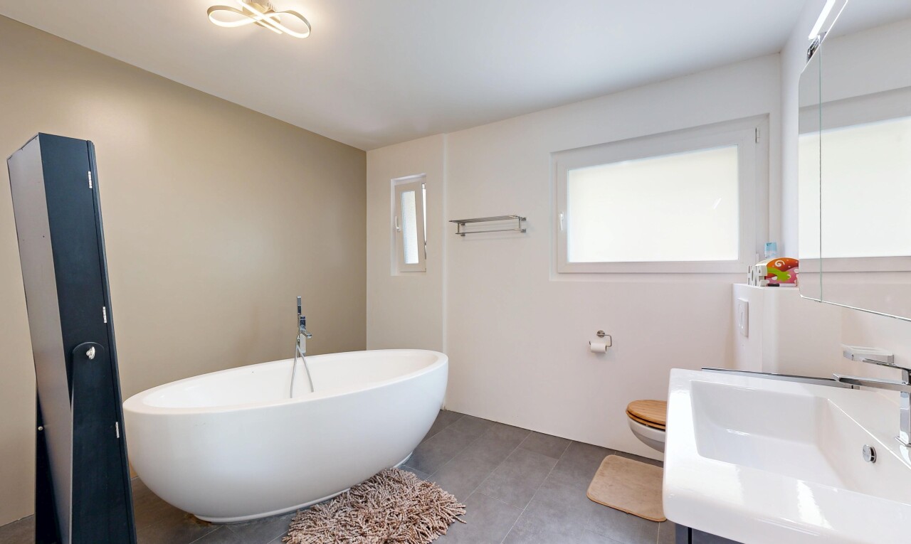 salle de bains avec bain, lavabo (ou coiffeuse selon le contexte), miroir, salle de bain complète, et inside property