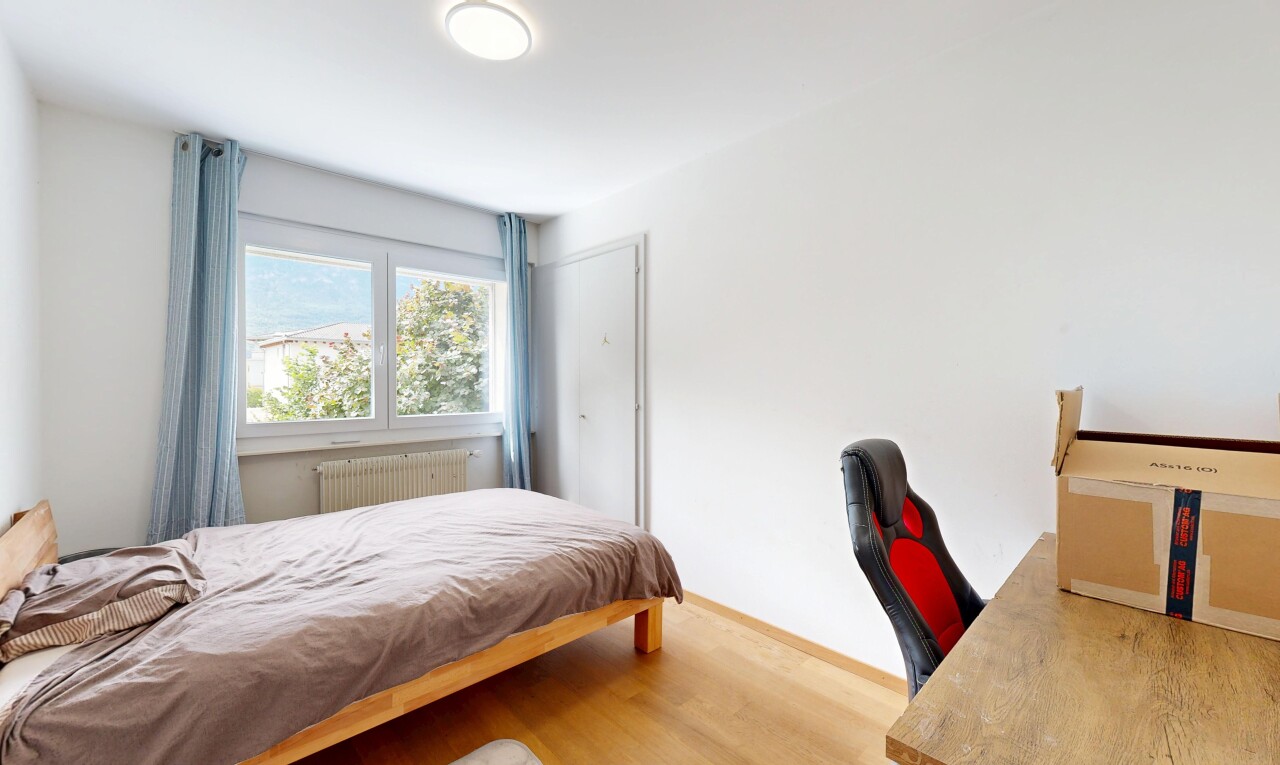 chambre avec cloison sèche, drywall, sol en finition bois, wood finish floor, et lumière naturelle
