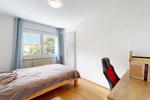 chambre avec cloison sèche, drywall, sol en finition bois, wood finish floor, et lumière naturelle