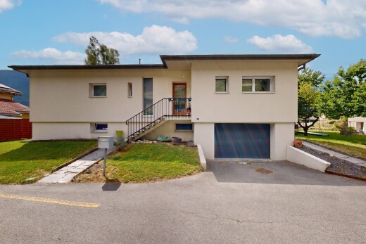 façade avec property visible, pelouse, garage intégré, garage au sous-sol, et bardage en stuc
