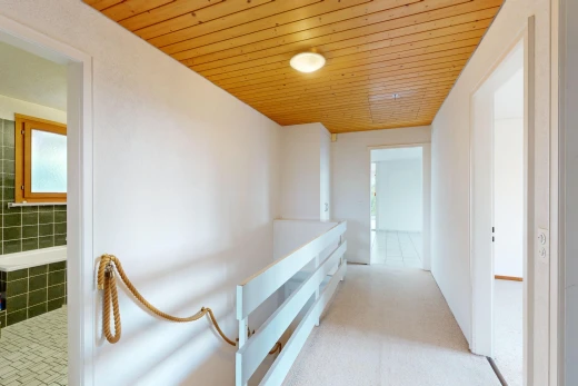 halle / korridor mit teppich, natürliches licht, holzdecke, und fliesenwand