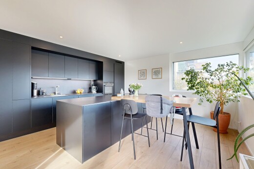 küche mit schränke mit flachen paneelen, küchenbar, wood finish floor, holzfußboden, und natural light