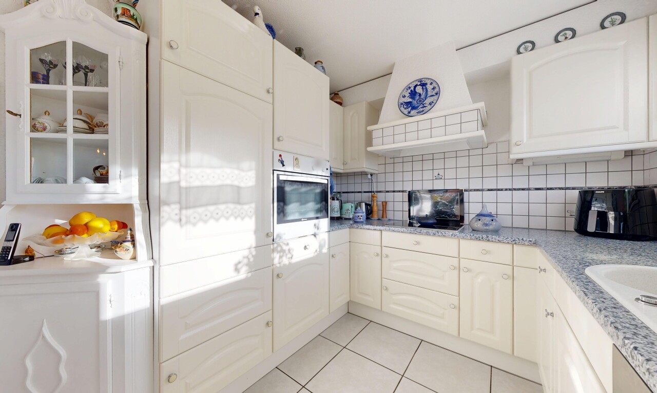 cuisine avec armoires en arc, hotte, inside property, tile floor, et sol en carrelage