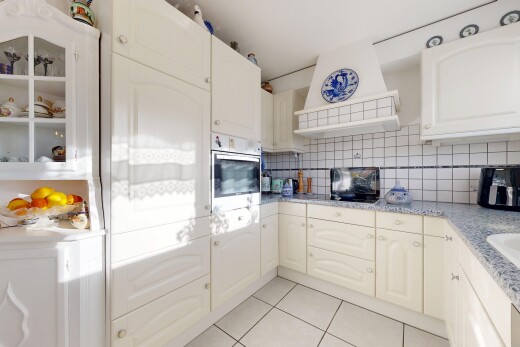 cuisine avec armoires en arc, hotte, inside property, tile floor, et sol en carrelage