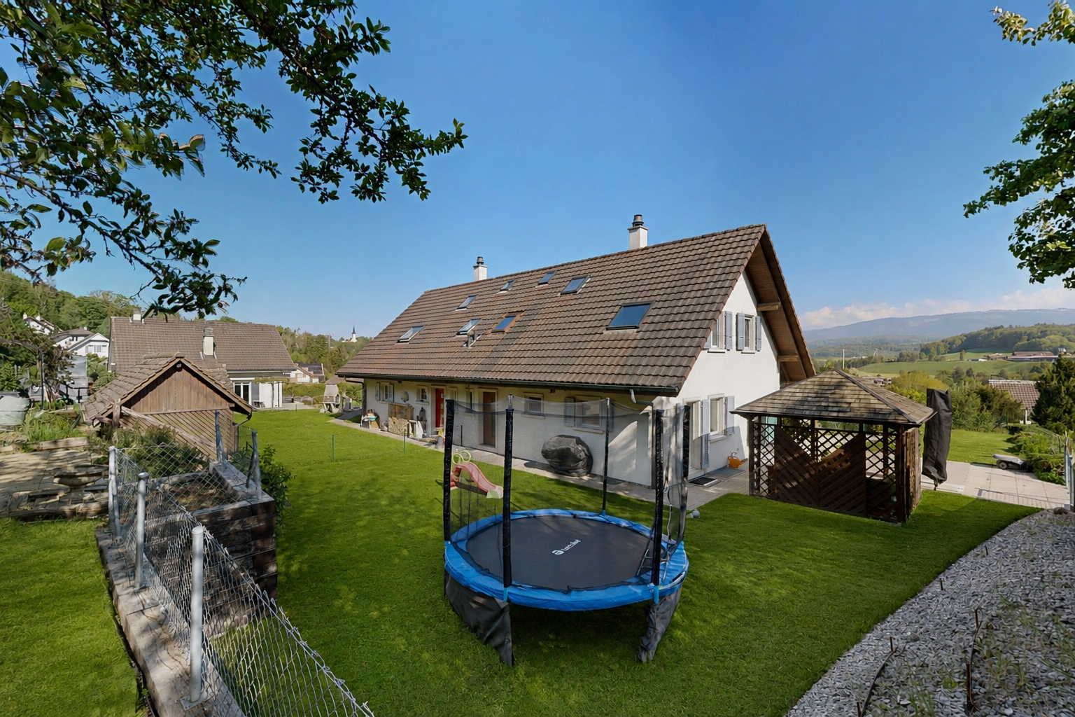 façade avec cheminée, pelouse, day time, property visible, et trampoline
