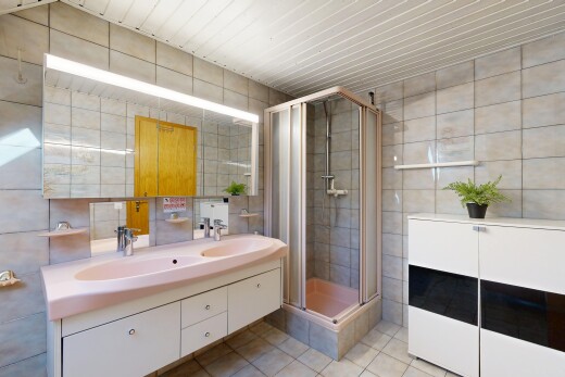 salle de bains avec mur en carrelage, tile wall, douche, double vasque, et salle de bain complète