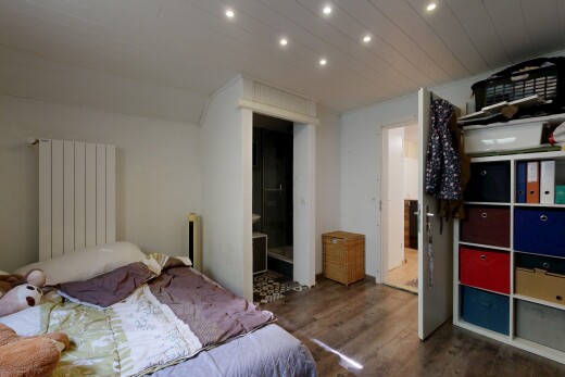 chambre avec radiateur, sol en finition bois, wood finish floor, inside property, et éclairage encastré