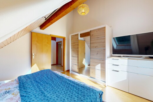 chambre avec télévision, light floor, sol en finition bois, wood finish floor, et plafond à poutres