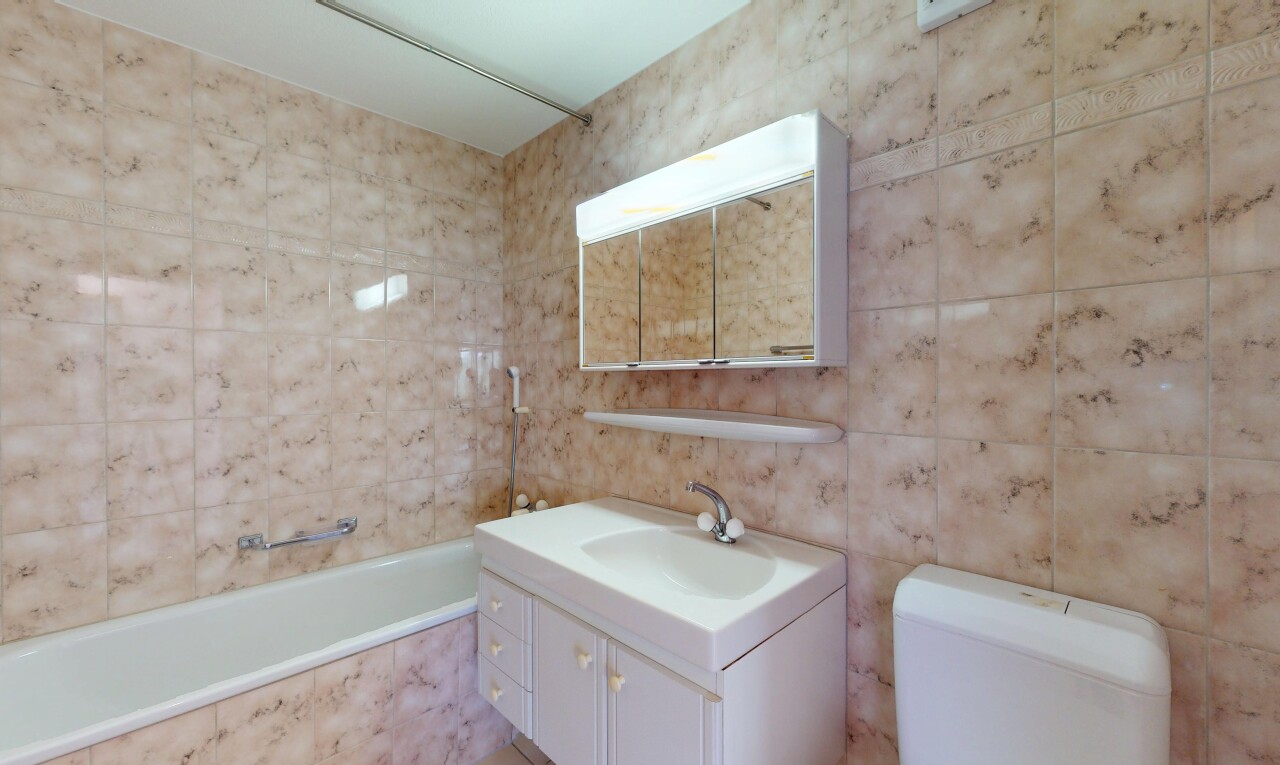 salle de bains avec tile tub, tile wall, mur en carrelage, inside property, et miroir