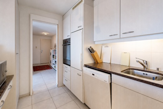 cuisine avec dark countertops, plans de travail en pierre, stone countertops, lave-vaisselle, et four