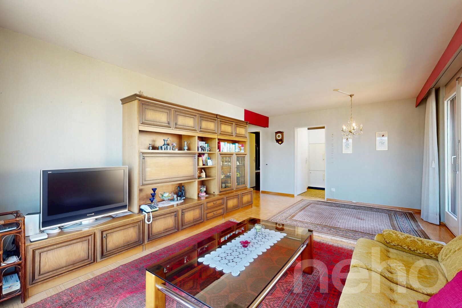 wohnzimmer mit fernseher, inside property, gipskartonwand, drywall, und bemerkenswerter kronleuchter