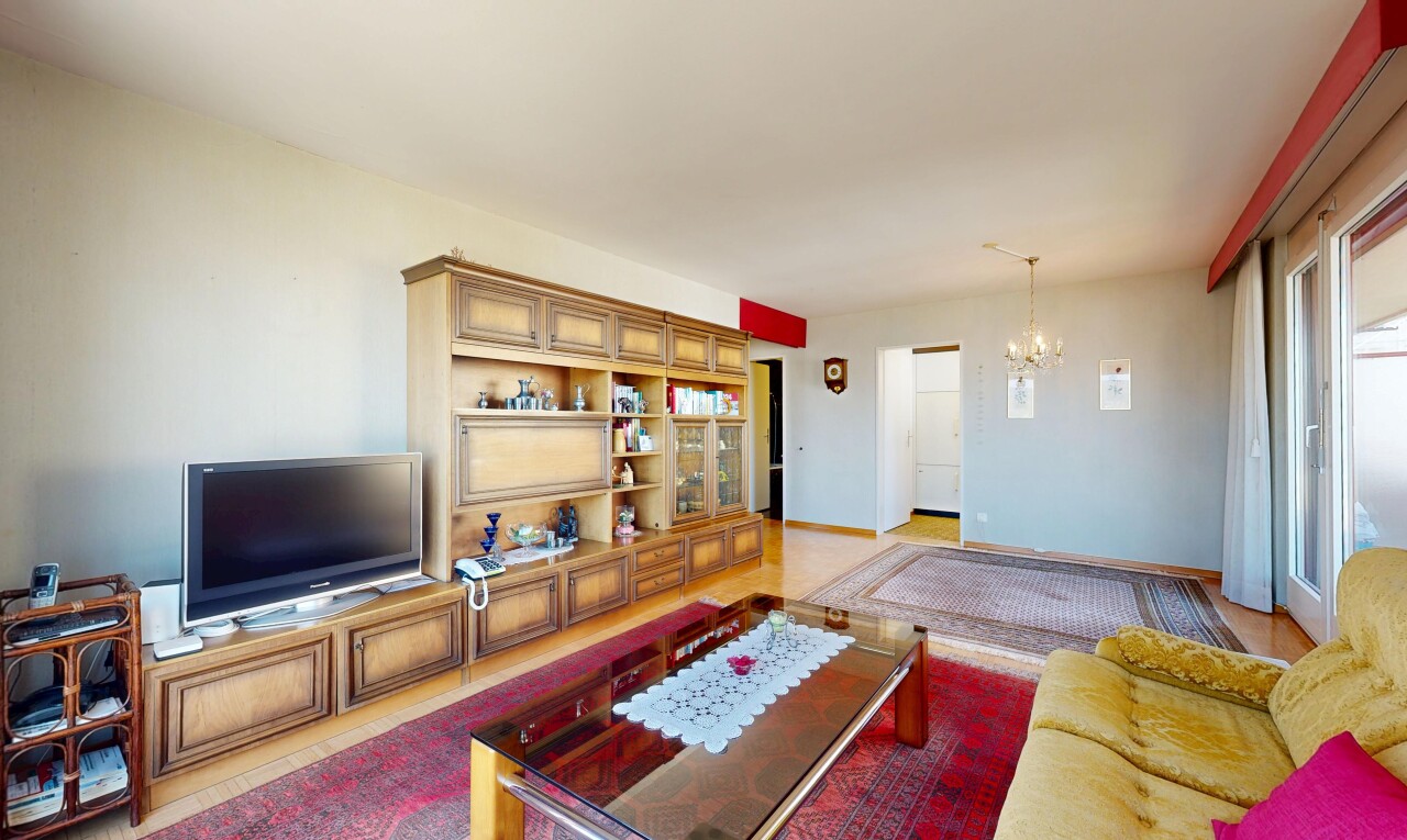wohnzimmer mit fernseher, inside property, gipskartonwand, drywall, und bemerkenswerter kronleuchter